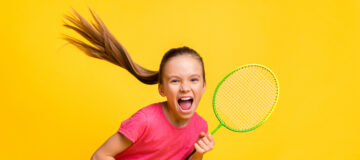 Photo of purposeful cute small schoolgirl dressed pink t-shirt screaming shouting playing tennis isolated yellow color background